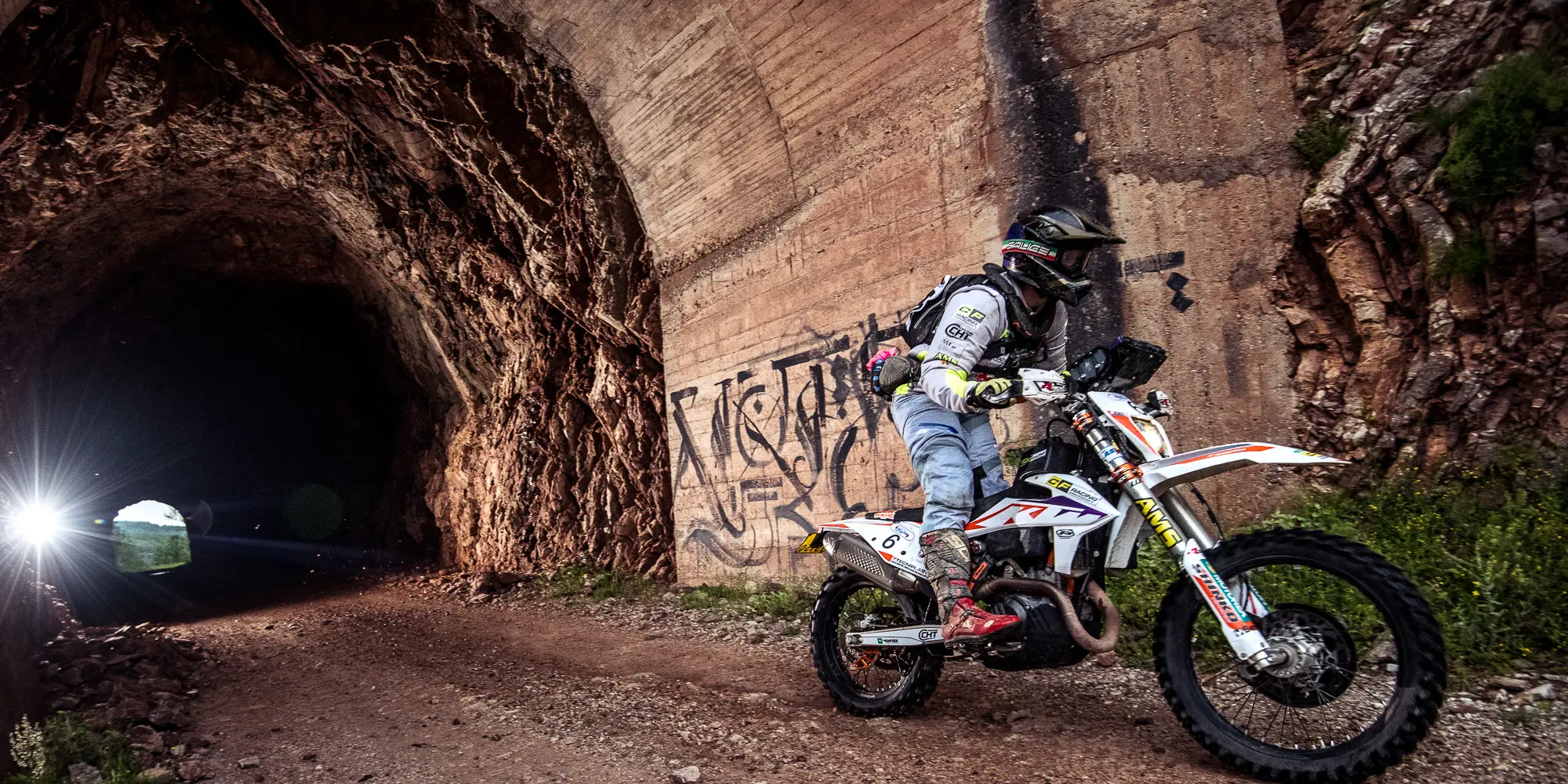 Jasmin Riccius riding out of a tunnel on an enduro stage