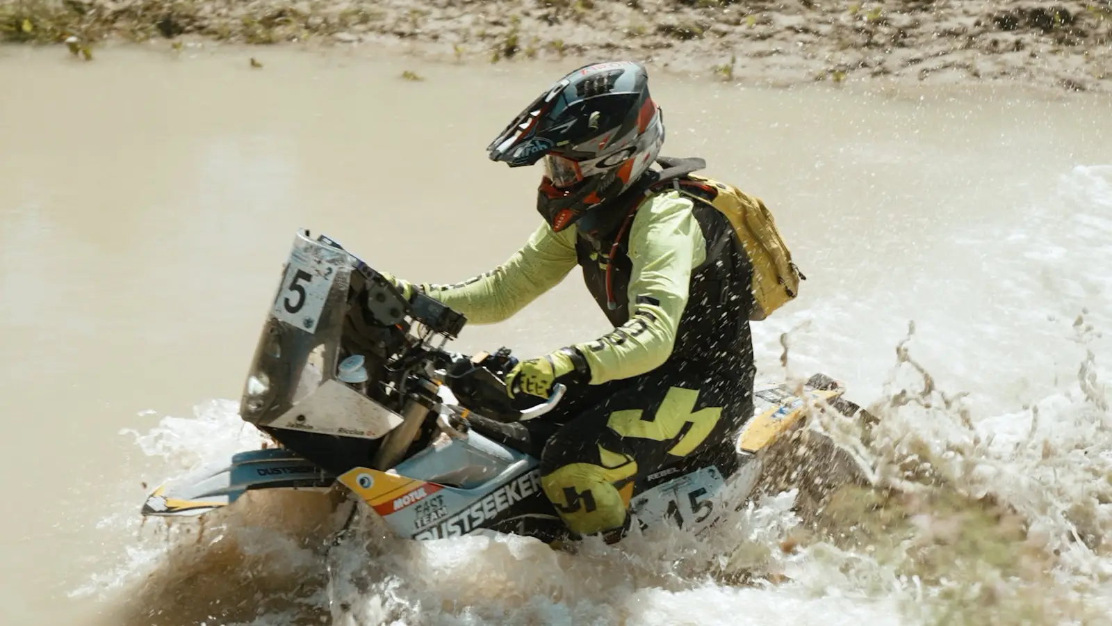 Riding through a deep water crossing, spray flying to both sides